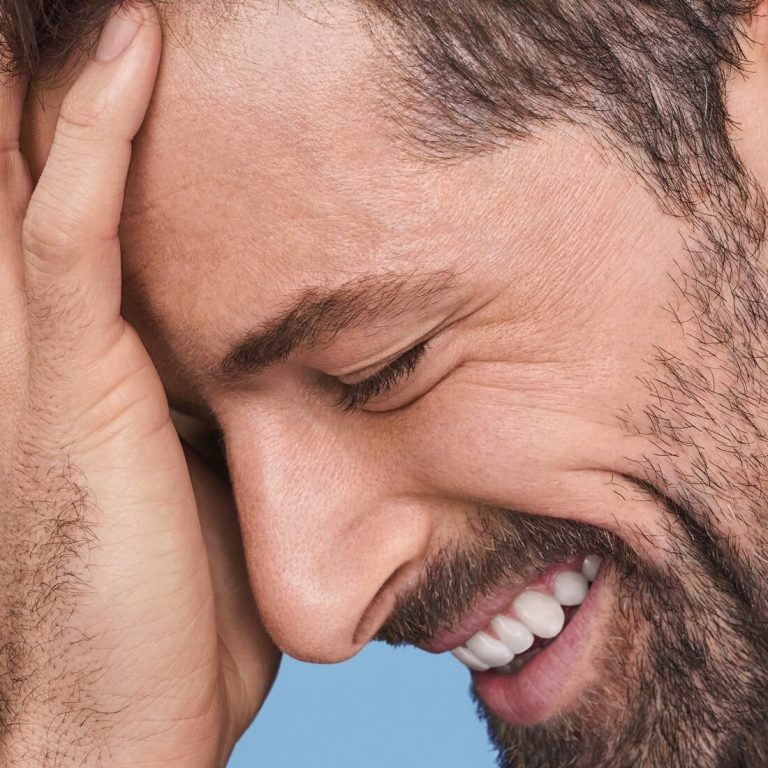 Closeup of man with full beard smiling with eyes closed