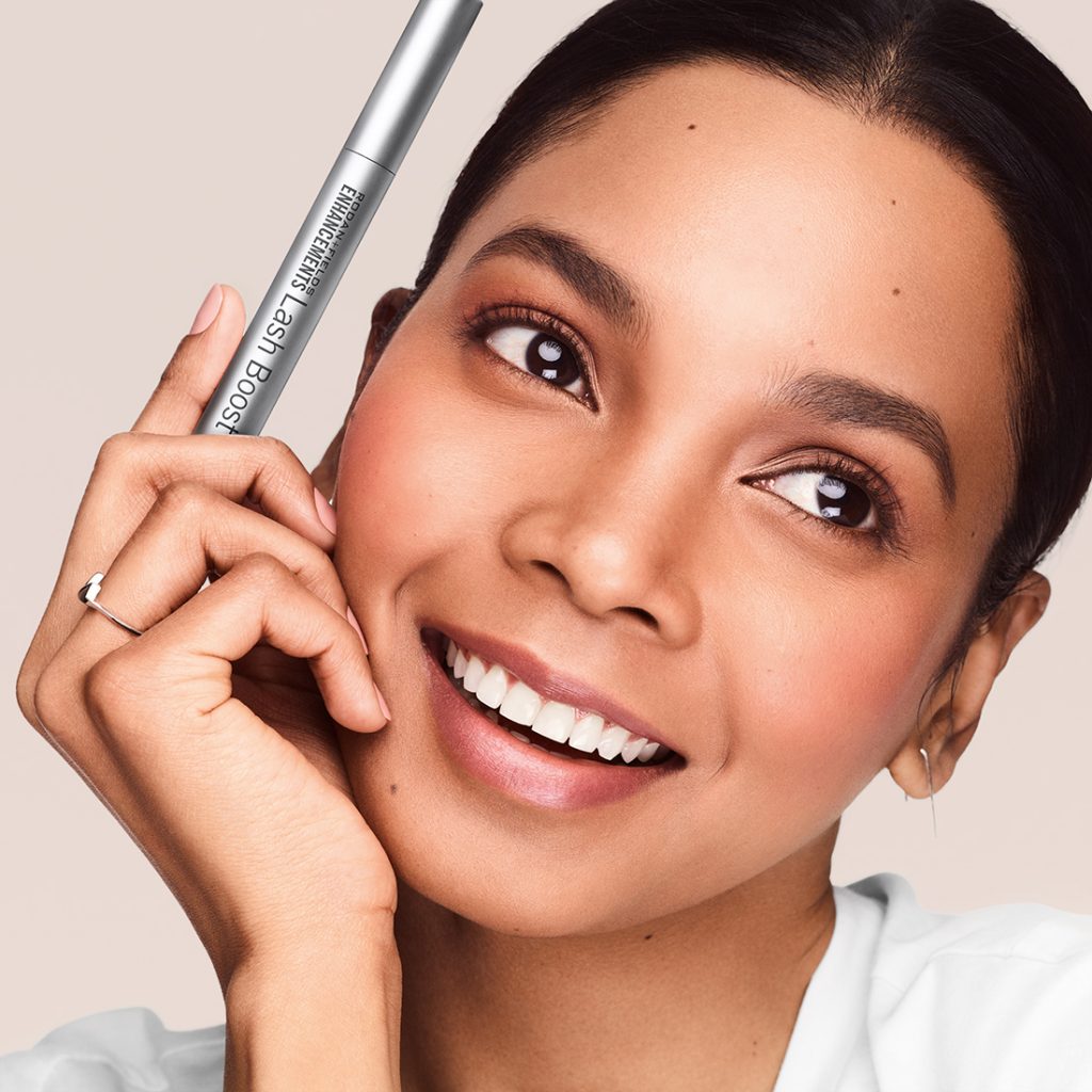 Close shot of model holding Rodan and Fields Lash Boost