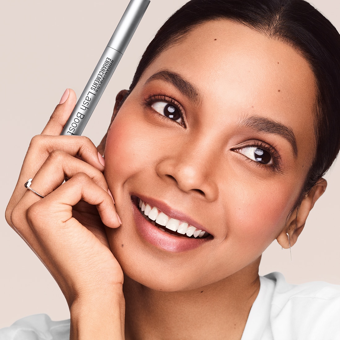 Close shot of model holding Rodan and Fields Lash Boost