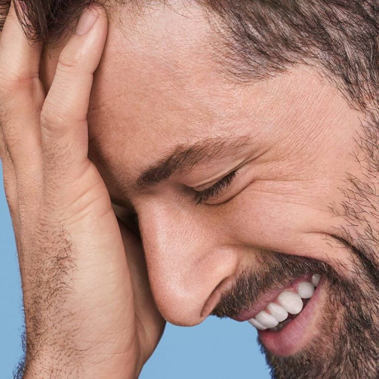Closeup of man with full beard smiling with eyes closed