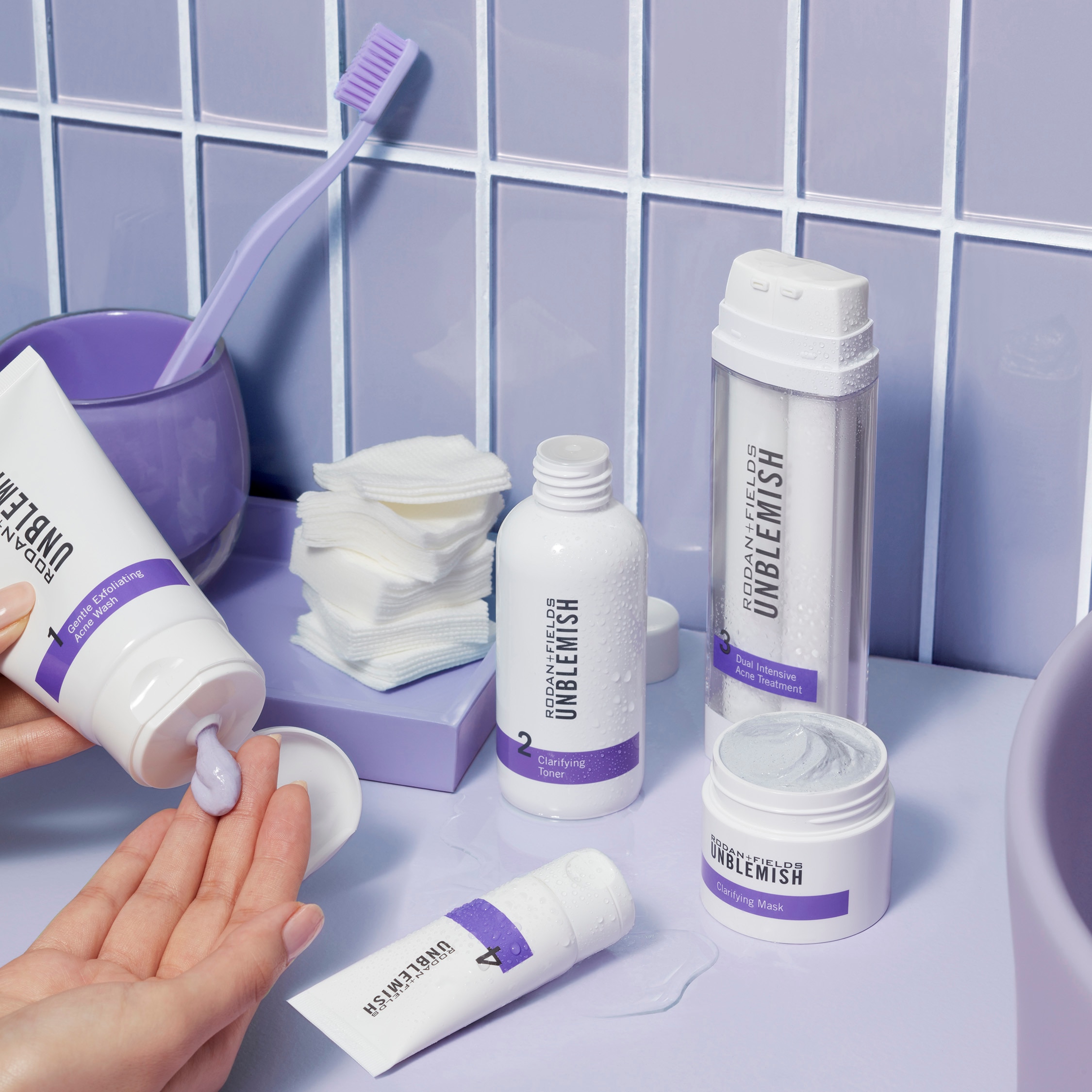 Unblemish Regimen applied to the hand on a bathroom counter