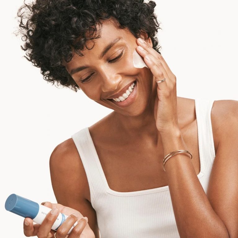 Woman applying Rodan + Fields Redefine product to her cheek