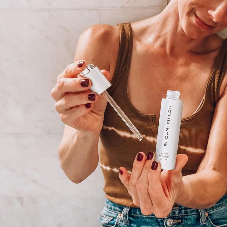 Woman holding an open container of Rodan and Field Active Hydration Serum