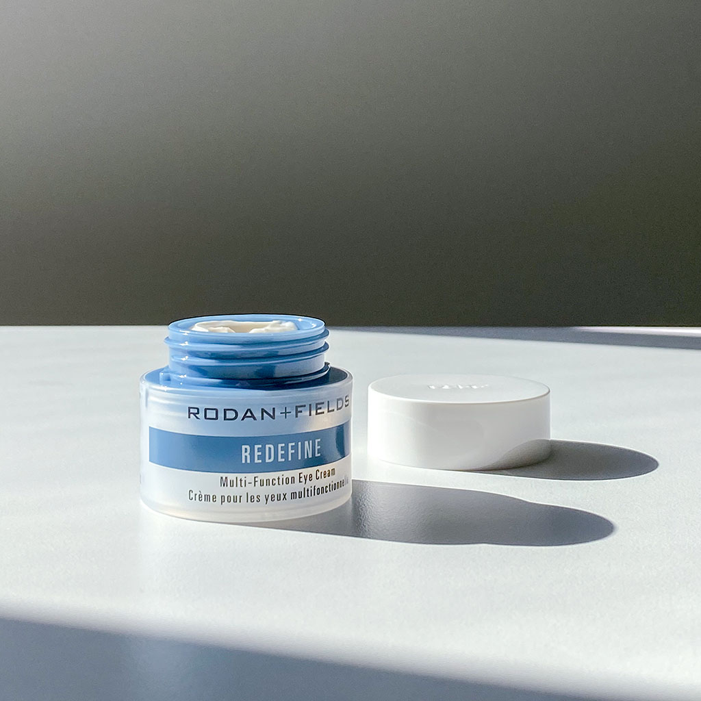 Open container of Rodan + Fields Multifunction Eye Cream on a white surface