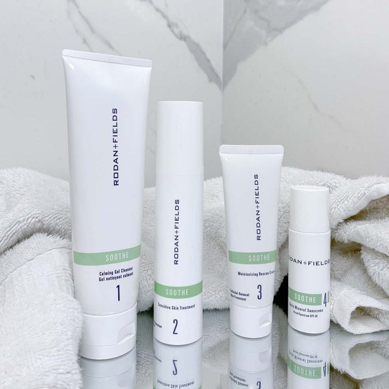 Rodan + Fields Soothe Regimen pictured on a mirror surface with a towel in a marble bathroom