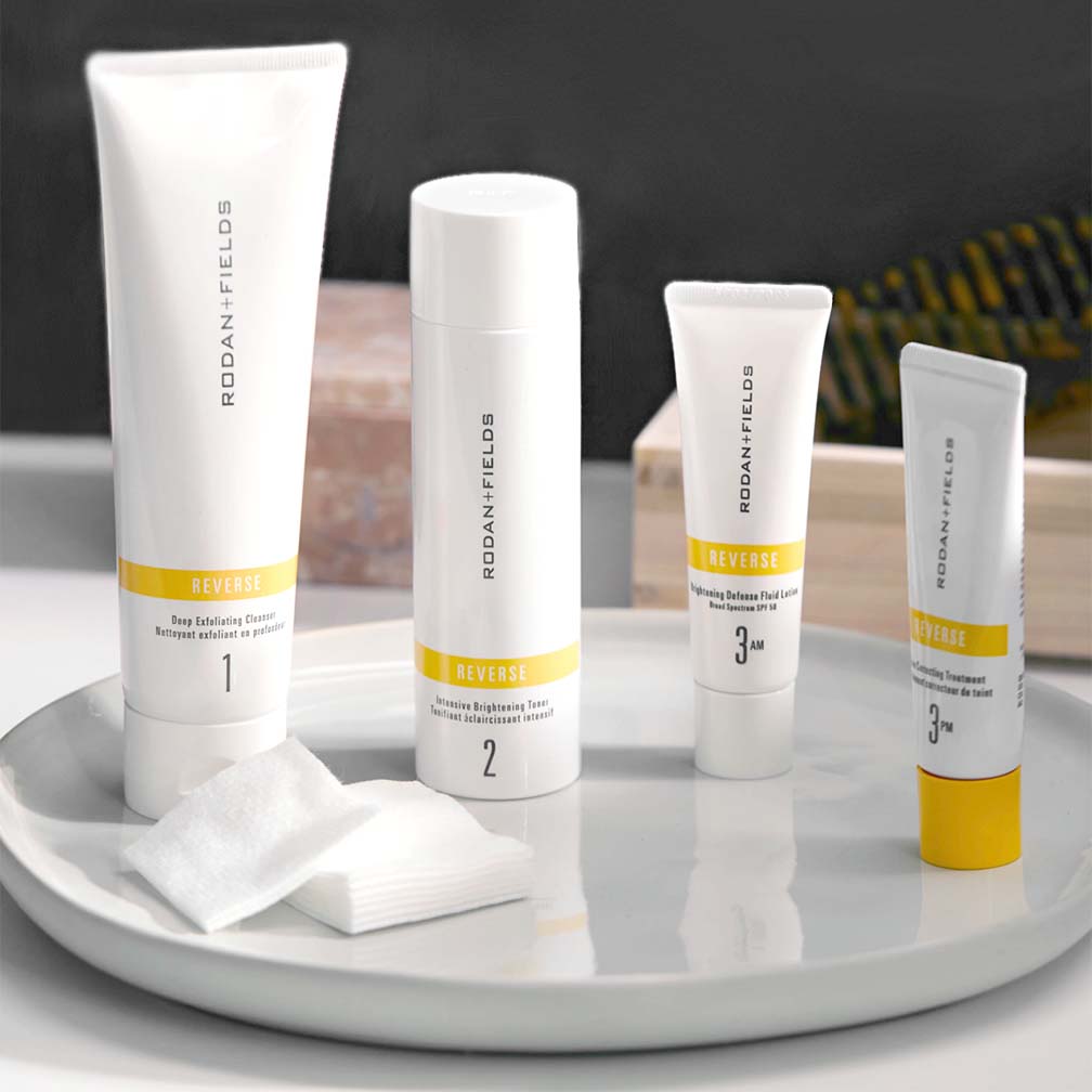 Rodan + Fields Reverse Regimen pictured with gauze pads on porcelain platter on a bathroom counter