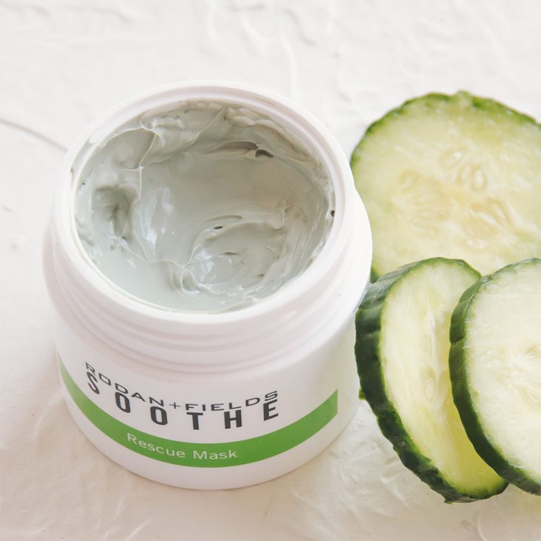 Open container of Rodan + Fields Soothe Rescue Mask on a textured surface with cucumber slices