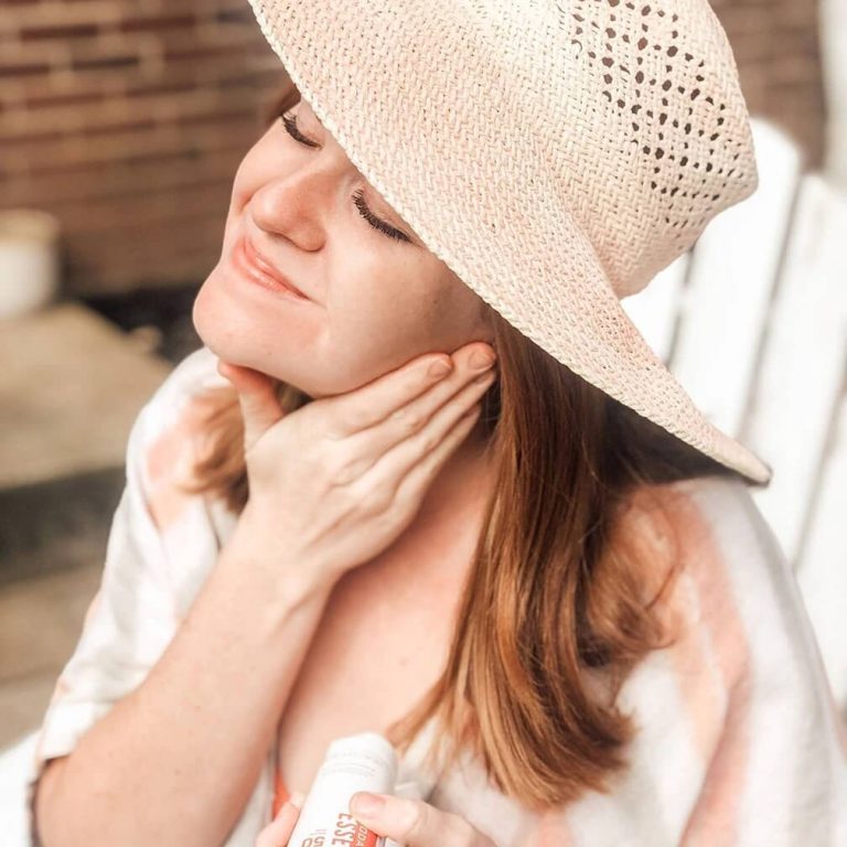 Young woman applying Rodan + Fields Essentials Face & Body Sunscreen to her neck