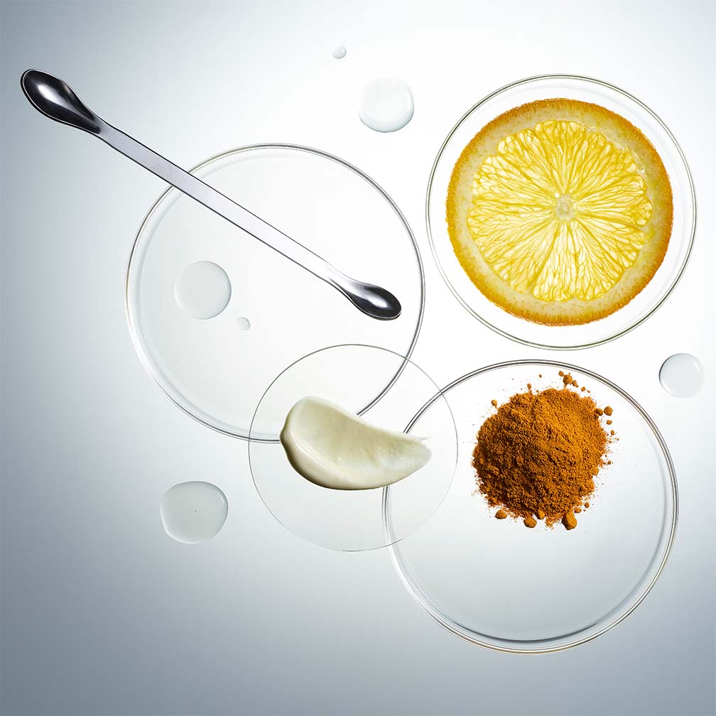 Glass petri dishes containing raw skincare ingredients