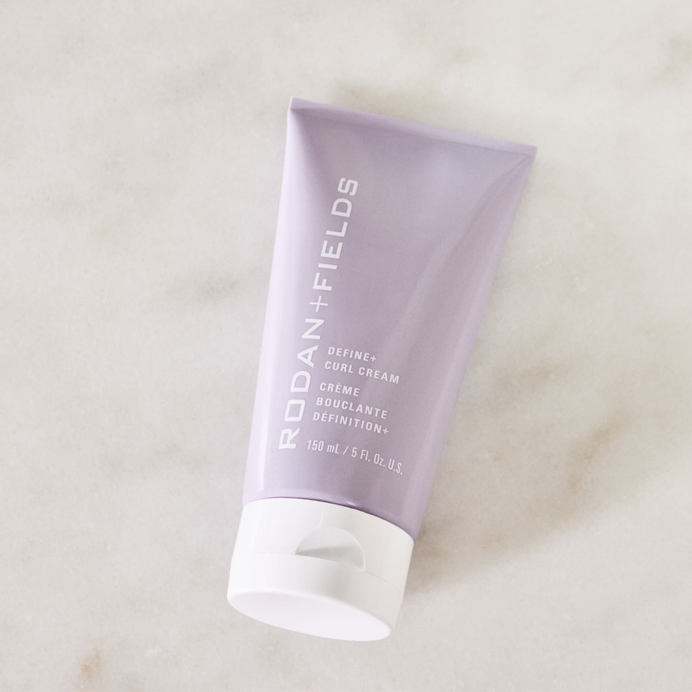 A tube of R+F Define+ Curl Cream on a marble countertop