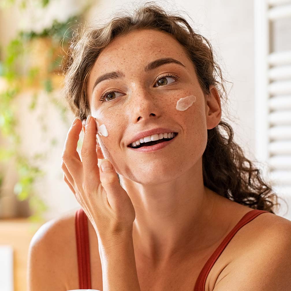 Young woman applying chemical peel product at home