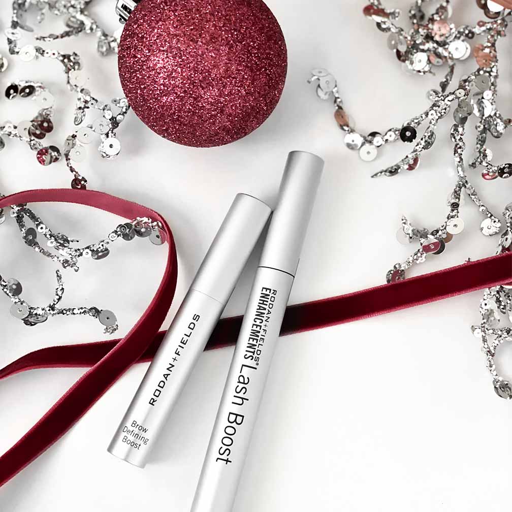 Rodan + Fields Lash Boost and Brow Defining Boost pictured with holiday ornaments and décor.