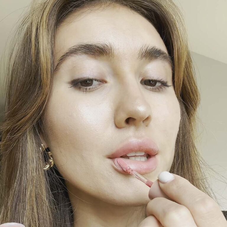 Young woman applying Rodan + Fields Lip Plumping Oil SPF 28