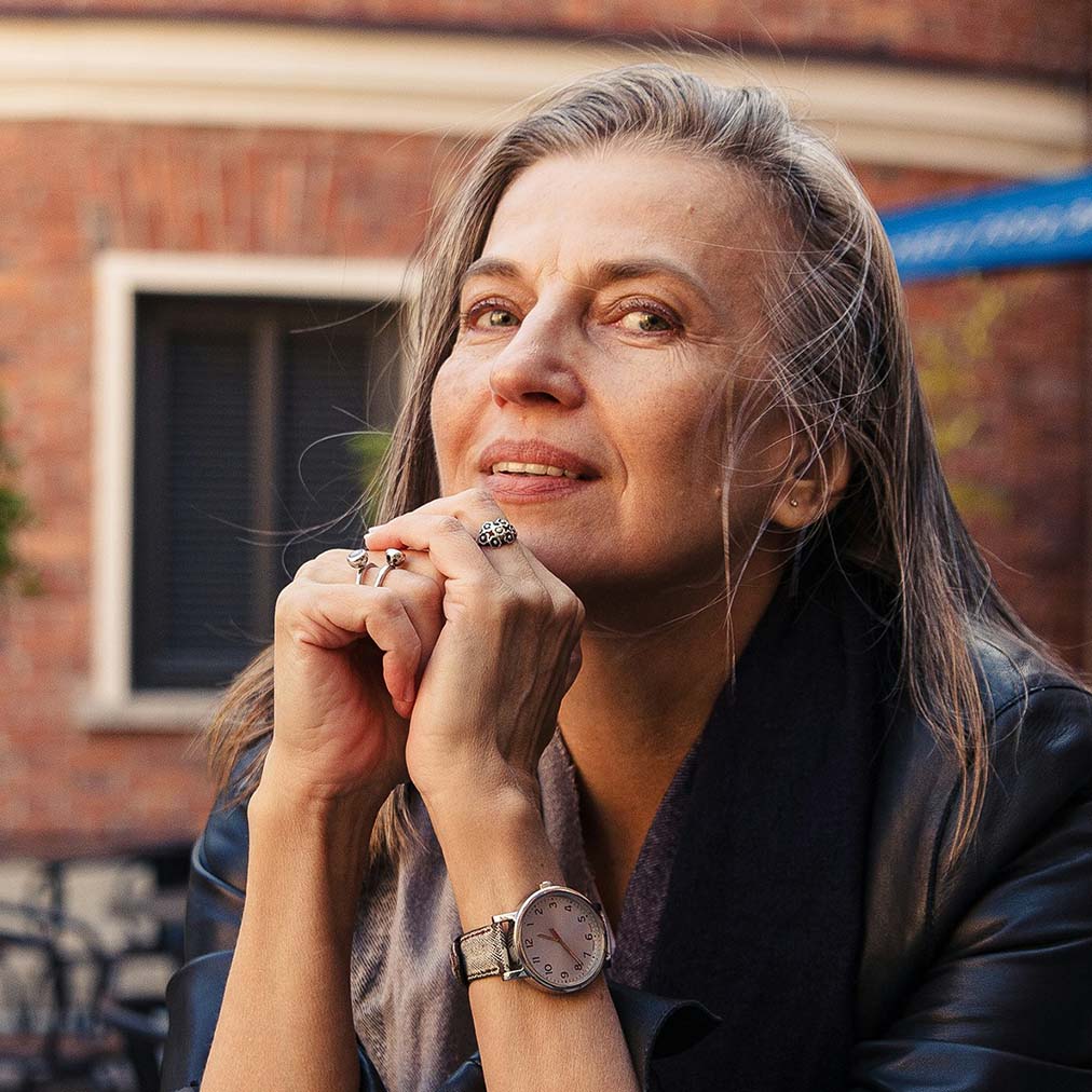 Woman sitting at an outdoor table with a cup of coffee. Photo by Daria Trofimova.