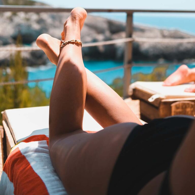 View of a woman sun-tanning on a balcony. Photo by Thomas Oldenburger