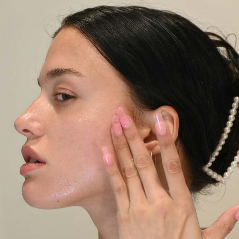 Woman with her hand on her face after applying serum. Photo by Laura Jaeger.