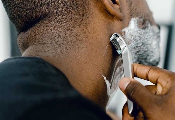 Man shaving face with foaming cleanser. Man shaving face with foaming cleanser.